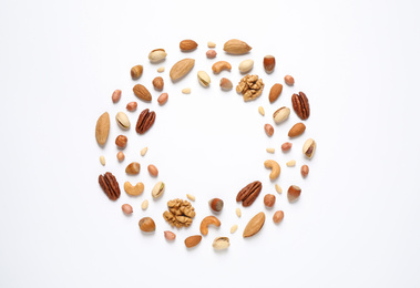 Different delicious nuts on white background, flat lay