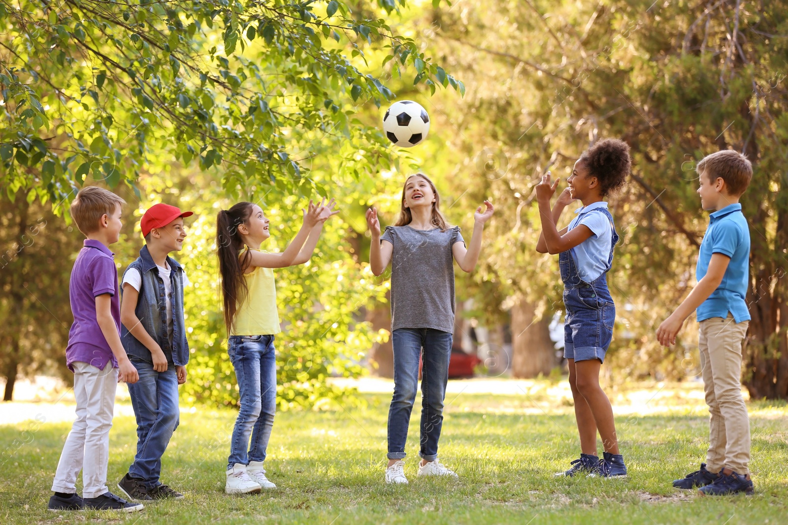 Photo of Cute little children playing with ball outdoors on sunny day