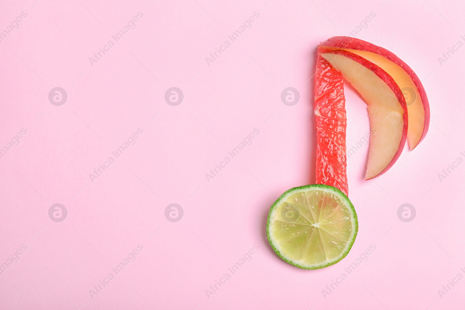 Photo of Musical note made of fruits on color background, top view. Space for text