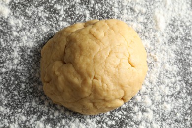 Photo of Making shortcrust pastry. Raw dough and flour on table, top view