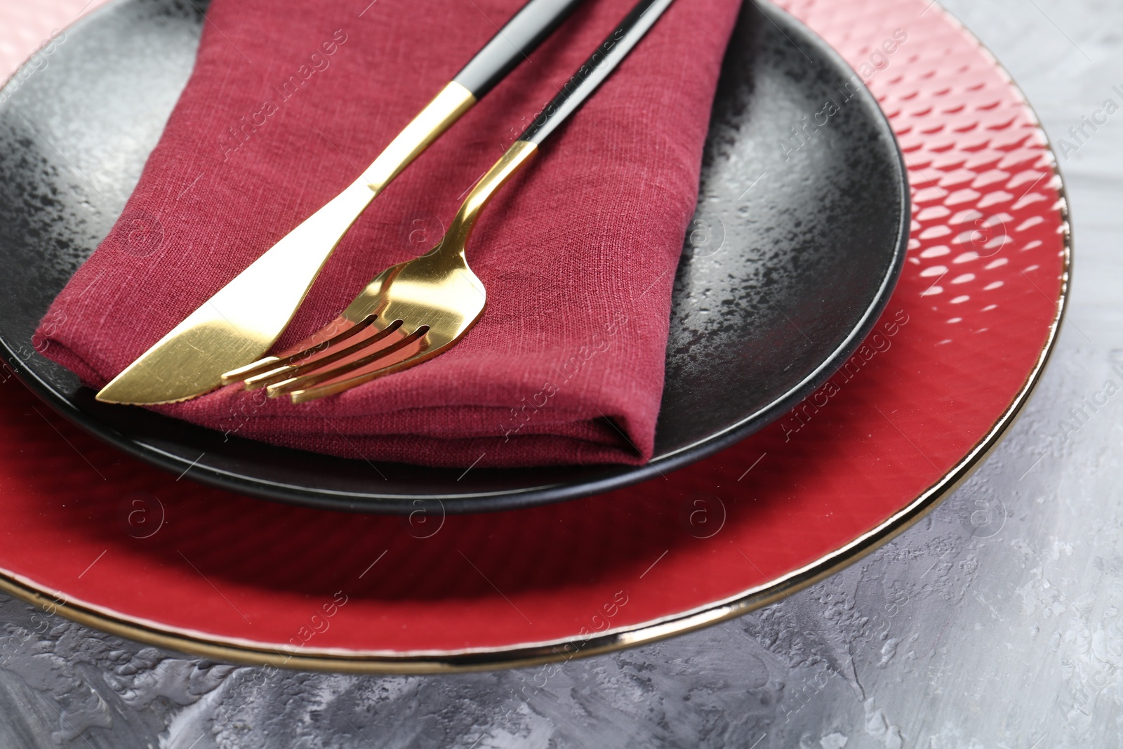 Photo of Clean plates, cutlery and napkin on table, closeup