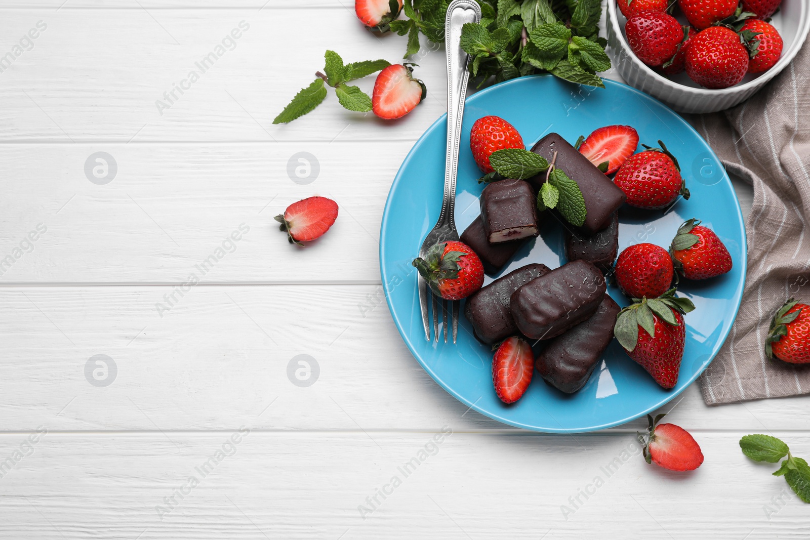 Photo of Delicious glazed curd snacks, mint leaves and fresh strawberries on white wooden table, flat lay. Space for text