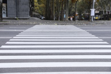 Photo of White pedestrian crossing on empty city street
