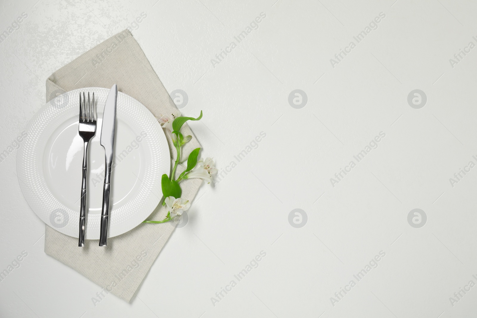 Photo of Stylish setting with elegant cutlery on white table, top view. Space for text