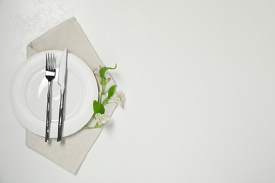 Stylish setting with elegant cutlery on white table, top view. Space for text