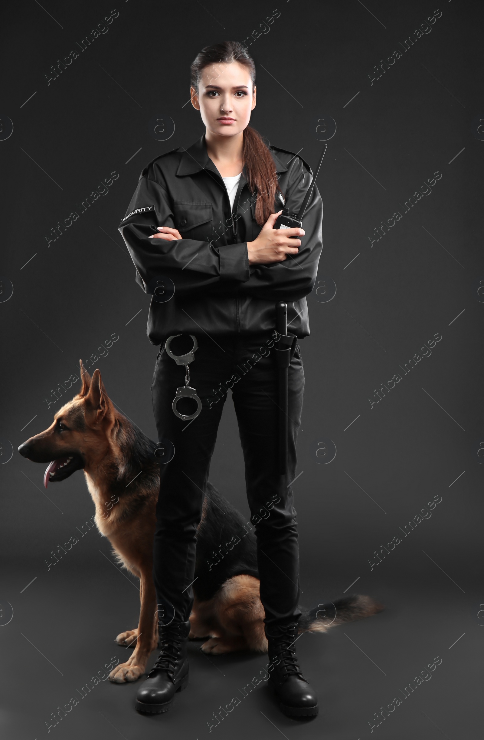 Photo of Female security guard with dog on dark background