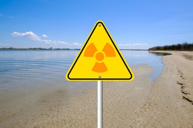 Image of Radioactive pollution. Warning sign with hazard symbol near sea side