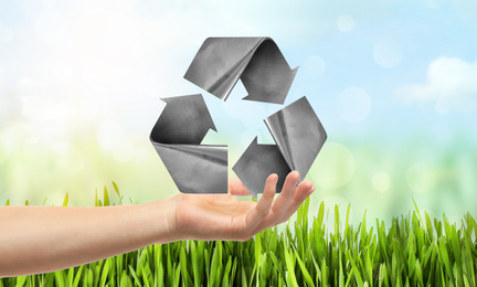 Image of Man with recycling symbol in hand outdoors, closeup 