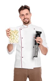 Photo of Smiling chef holding sous vide cooker and zucchini in vacuum pack on white background