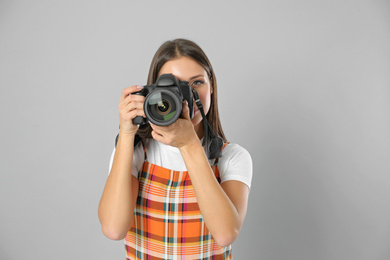 Photo of Professional photographer working on light grey background in studio