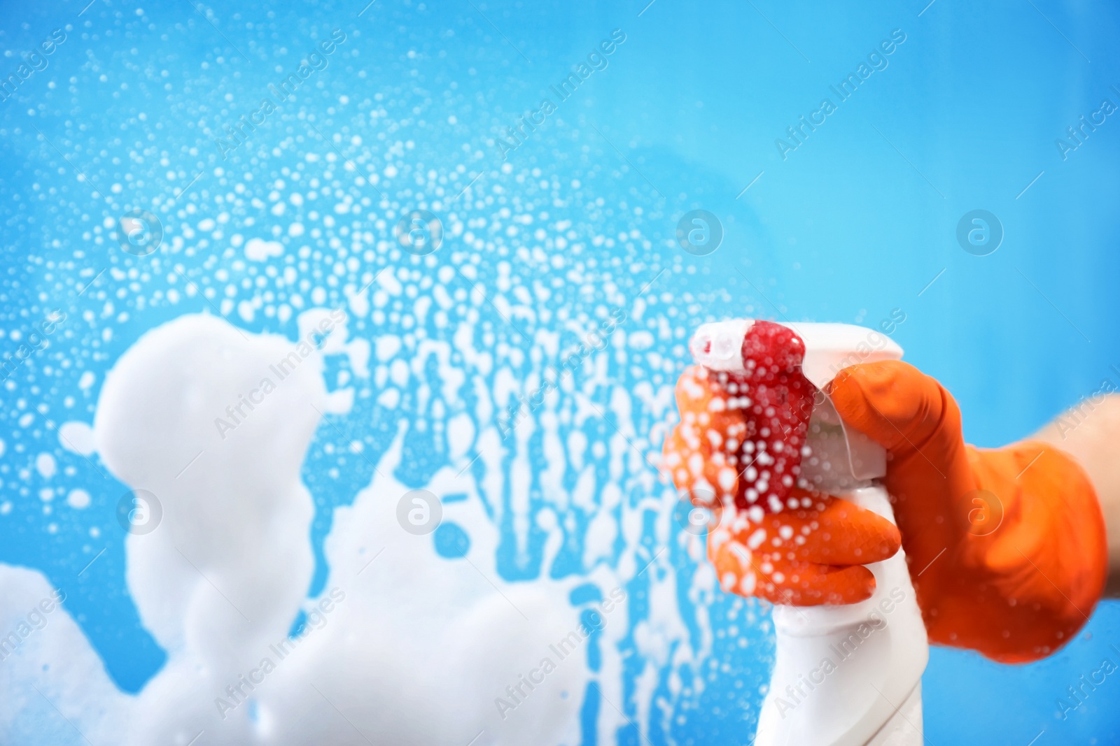 Photo of Woman cleaning glass against color background