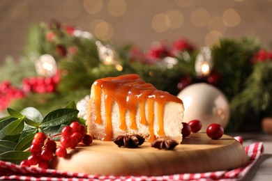 Tasty caramel cheesecake and Christmas decorations on table