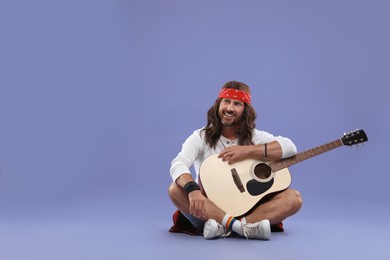 Photo of Stylish hippie man with guitar on violet background, space for text