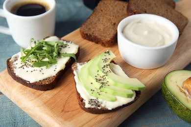 Photo of Slices of bread with different toppings on wooden board