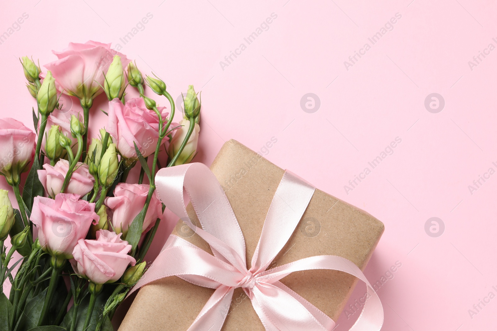 Photo of Happy Mother's Day. Beautiful flowers and gift box on pink background, flat lay. Space for text