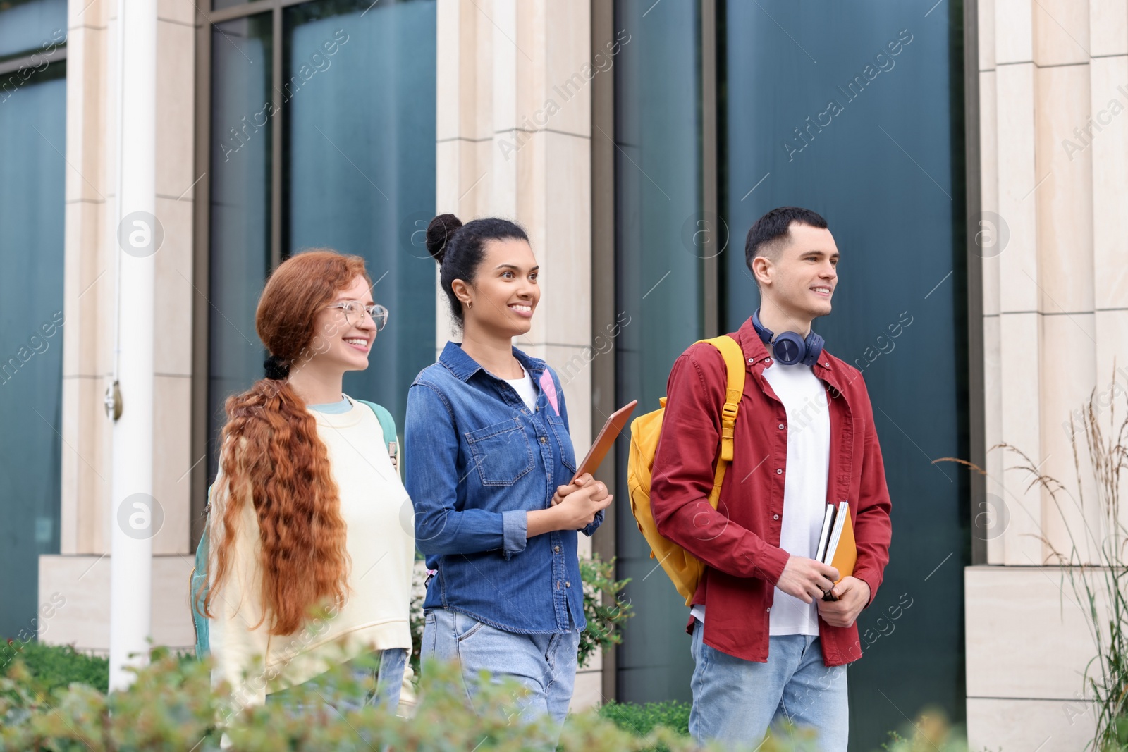 Photo of Group of happy young students walking together outdoors