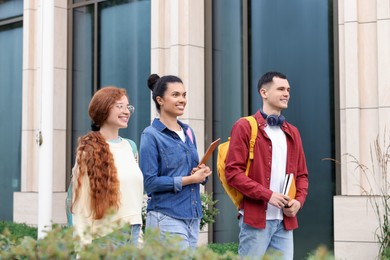 Photo of Group of happy young students walking together outdoors