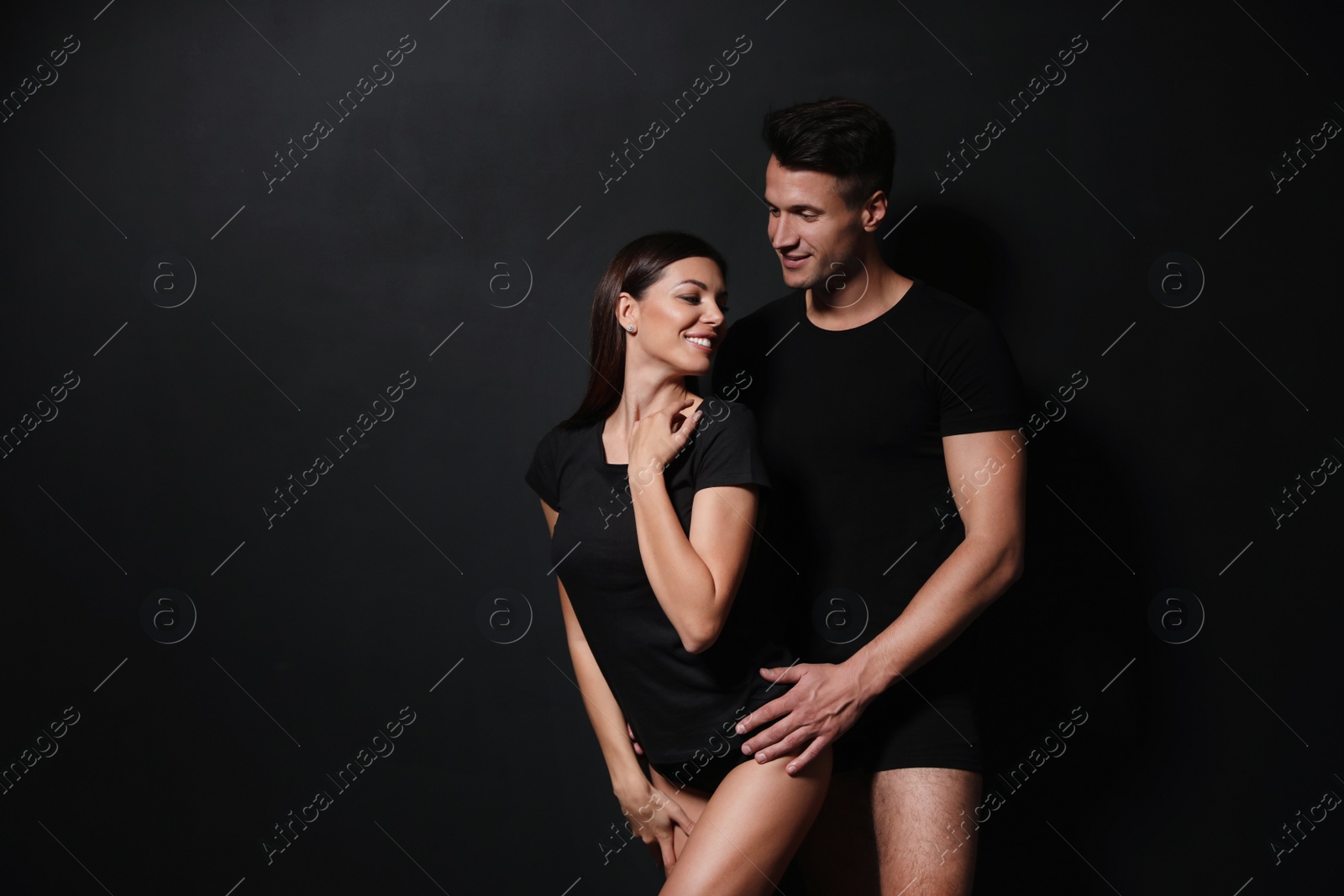 Photo of Young couple wearing underwear on black background