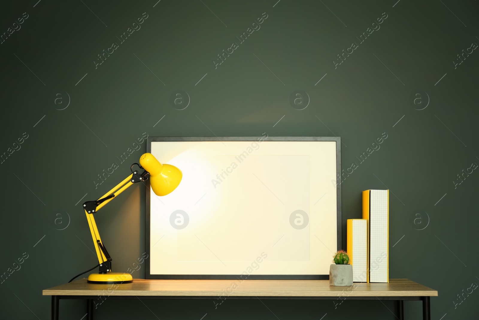 Photo of Mockup of blank frame and lamp on table