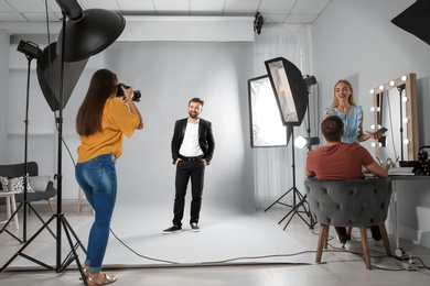 Photo of Professional team working with model in photo studio