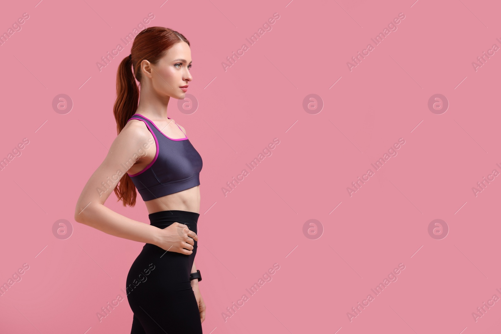 Photo of Young woman in sportswear on pink background, space for text