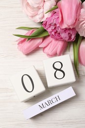 Photo of International Women's day - 8th of March. Block calendar and beautiful flowers on white wooden table, flat lay