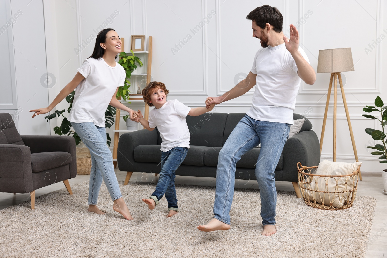 Photo of Happy family dancing and having fun in living room