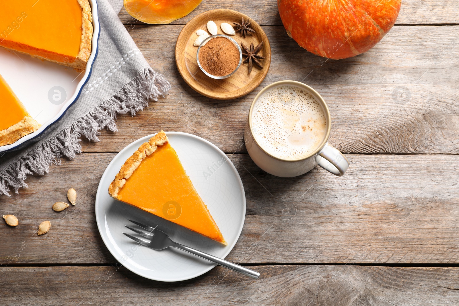 Photo of Flat lay composition with piece of fresh delicious homemade pumpkin pie on wooden background