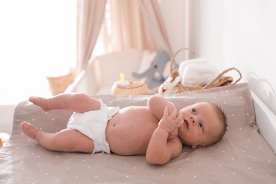 Cute little baby on changing table in room