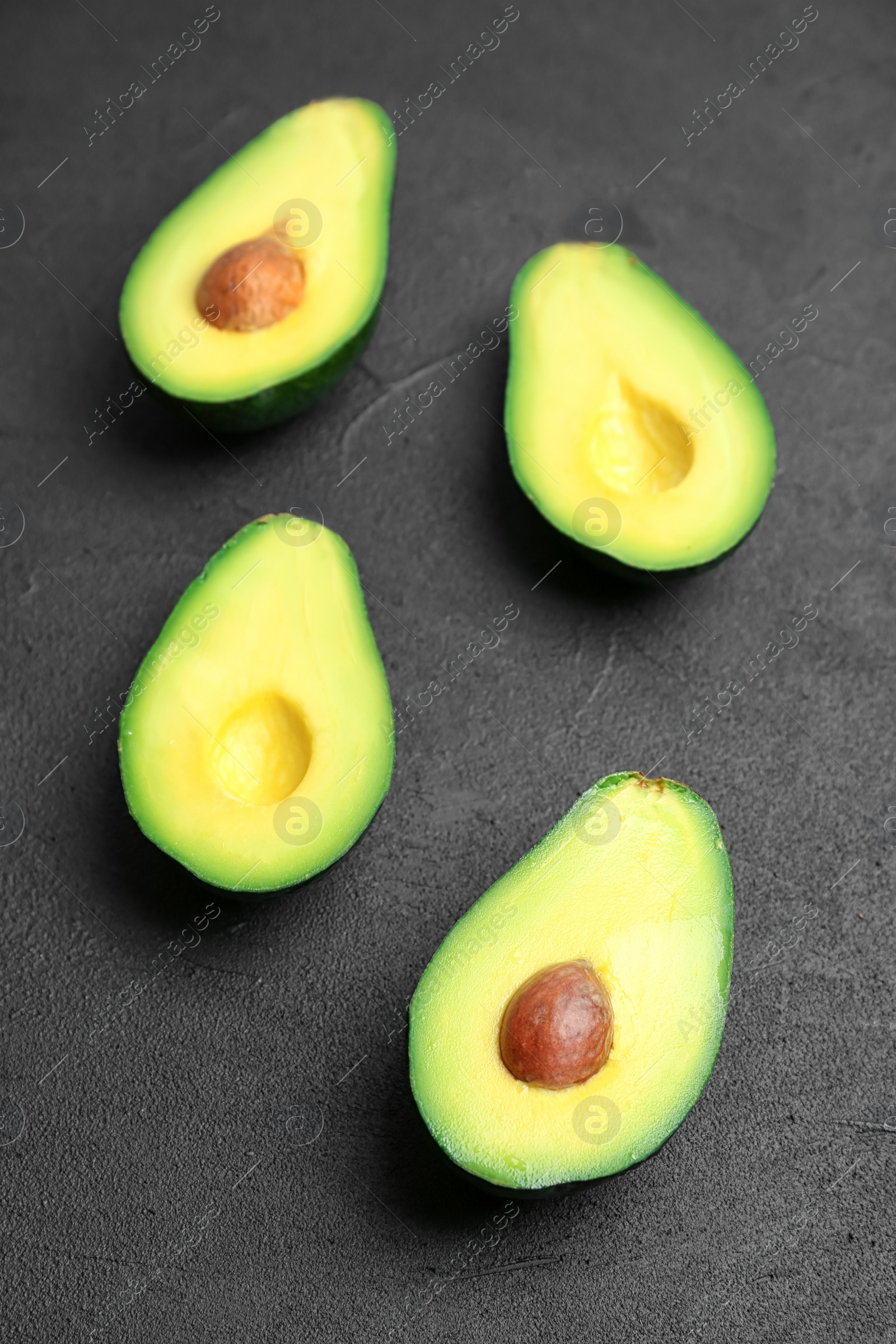 Photo of Fresh yummy avocado pieces on dark table