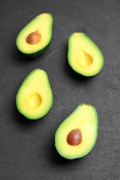 Fresh yummy avocado pieces on dark table