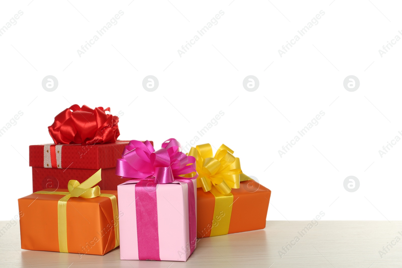 Photo of Colorful gift boxes on wooden table against white background, space for text