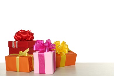 Colorful gift boxes on wooden table against white background, space for text