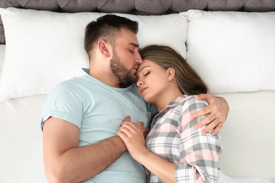 Photo of Young couple sleeping together in bed at home