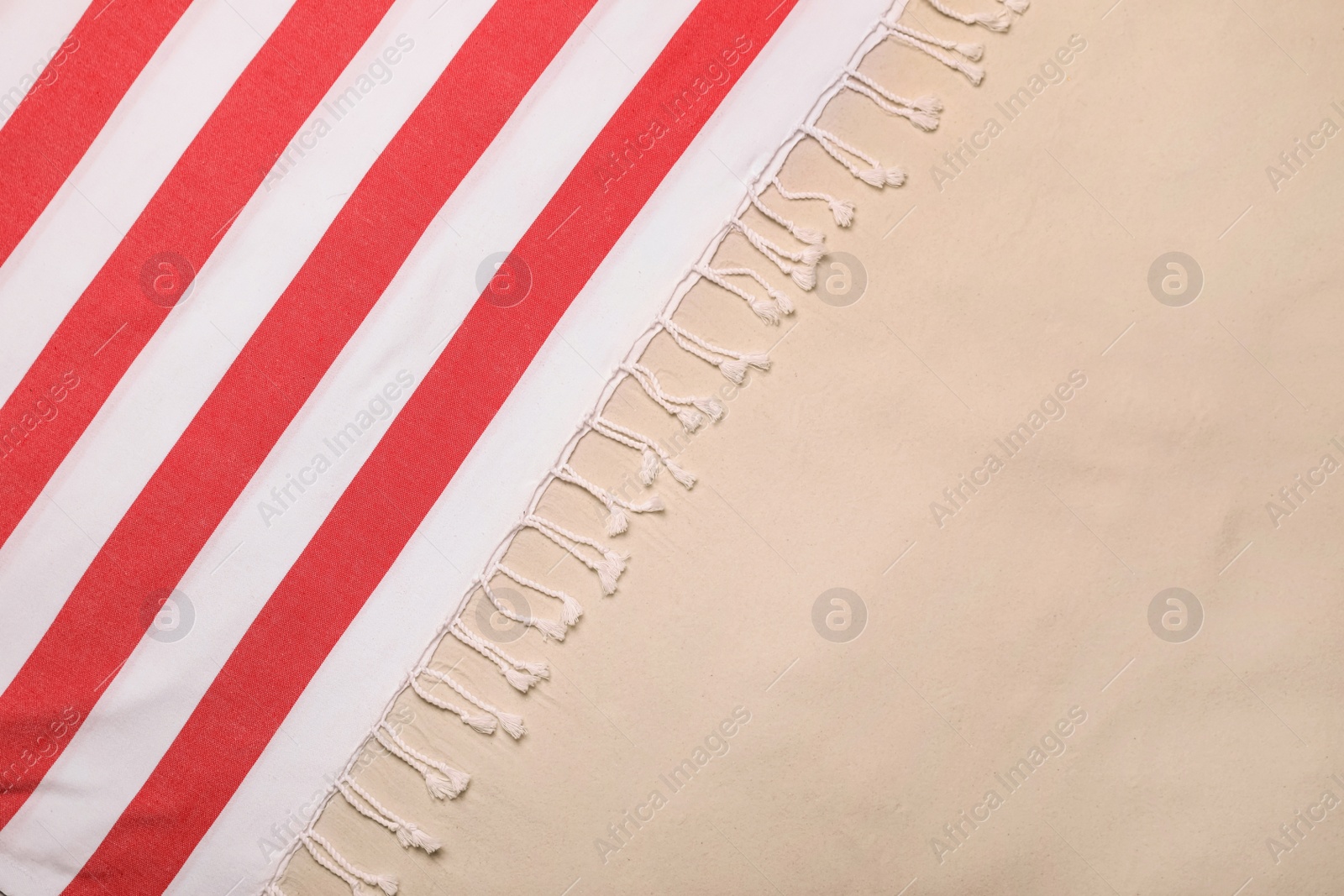 Photo of Striped beach towel on sand, top view. Space for text