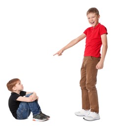 Photo of Boy laughing and pointing at upset kid on white background. Children's bullying