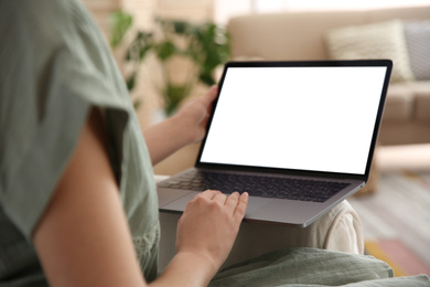 Woman using laptop at home, closeup. Space for design