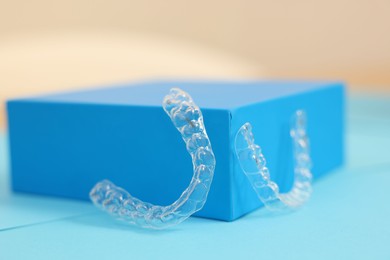 Photo of Transparent dental aligners on color background, closeup