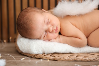 Cute newborn baby as Christmas angel in decorated studio