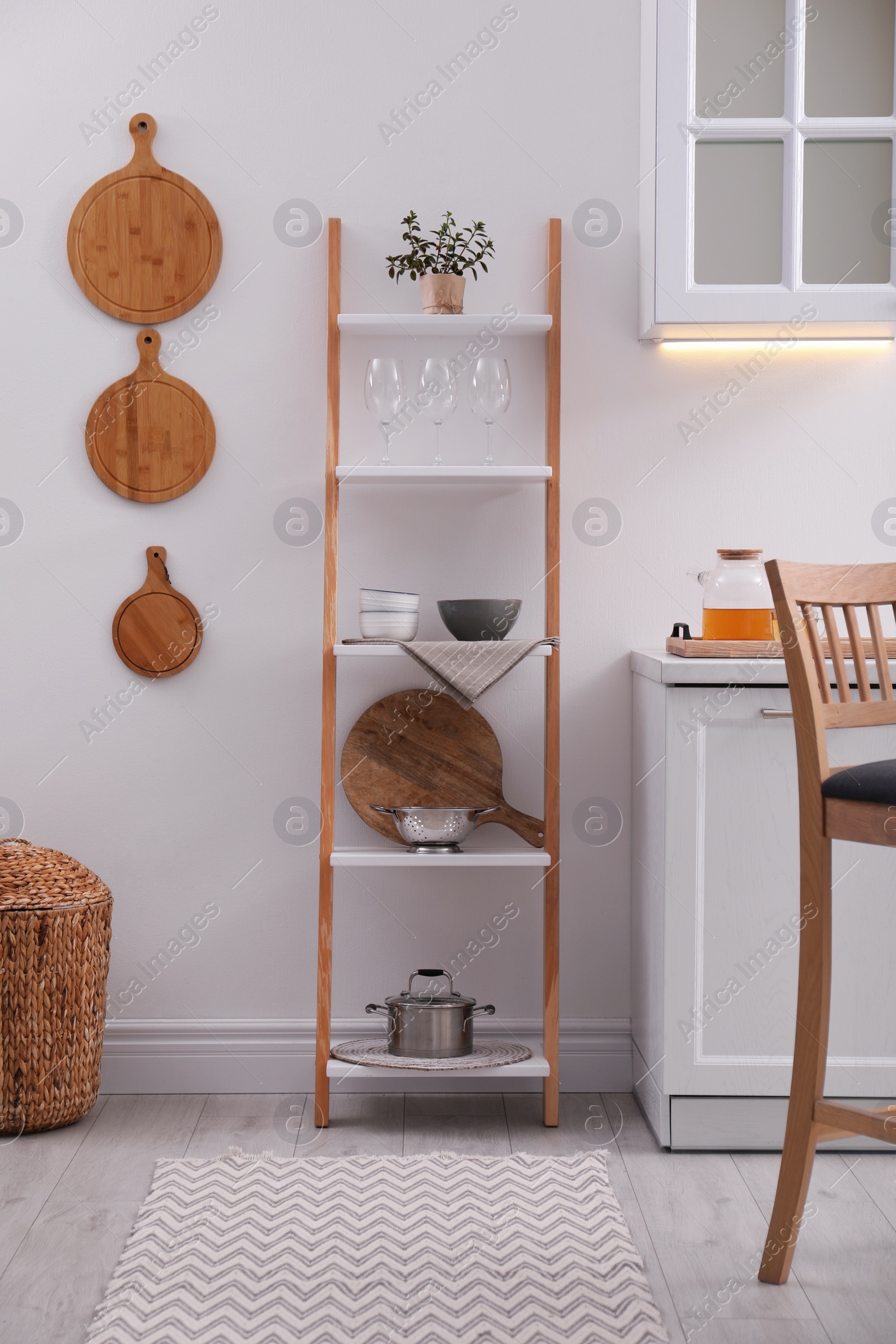 Photo of Stylish kitchen room interior with wooden ladder near white wall