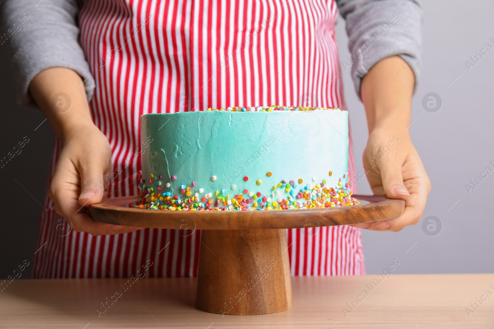 Photo of Woman with fresh delicious birthday cake on stand, closeup