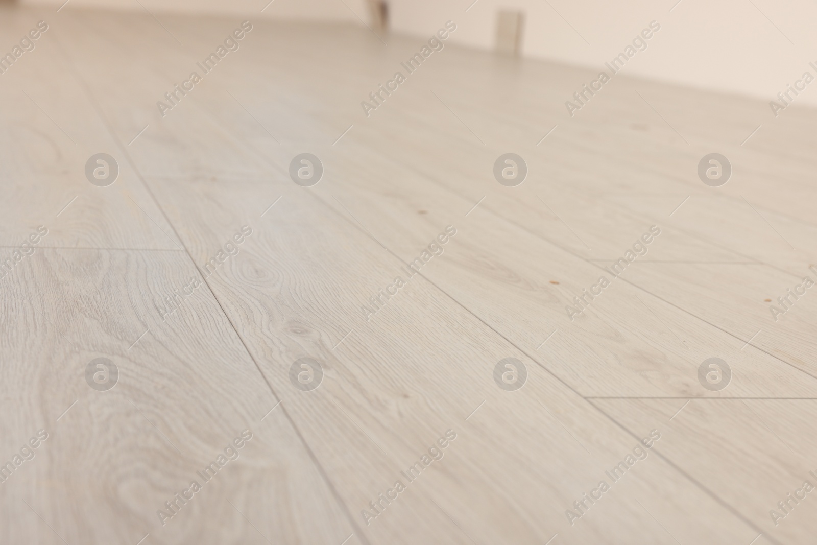 Photo of Empty room with new white laminated flooring, closeup