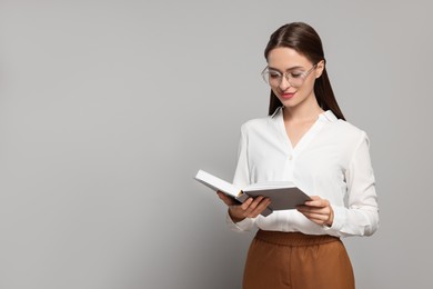 Portrait of beautiful young teacher on grey background. Space for text