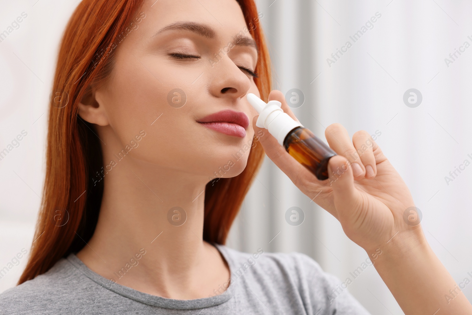 Photo of Medical drops. Woman using nasal spray at home