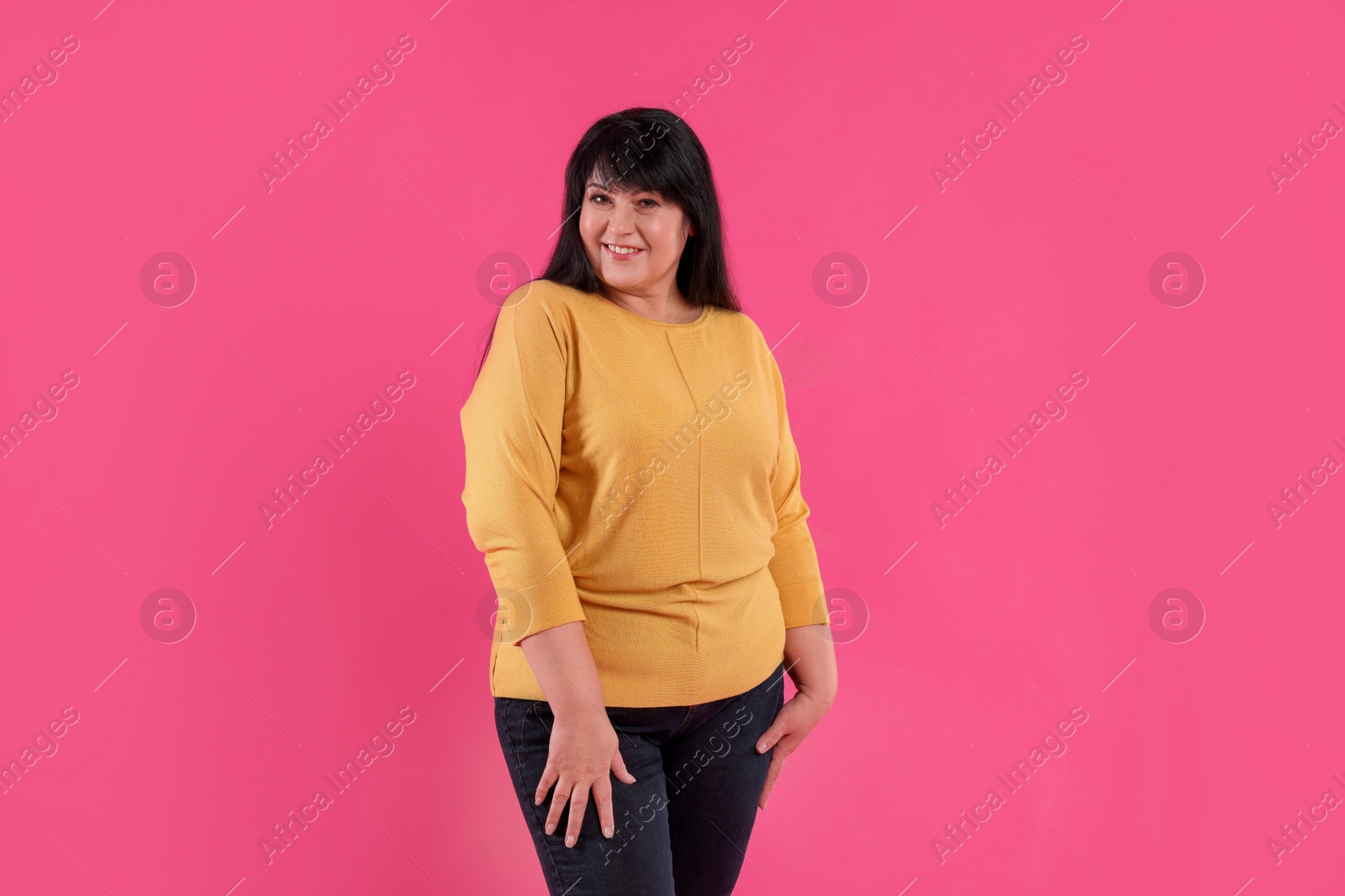 Photo of Beautiful overweight mature woman with charming smile on pink background