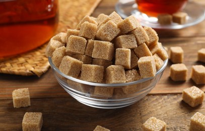 Photo of Brown sugar cubes on wooden table, closeup