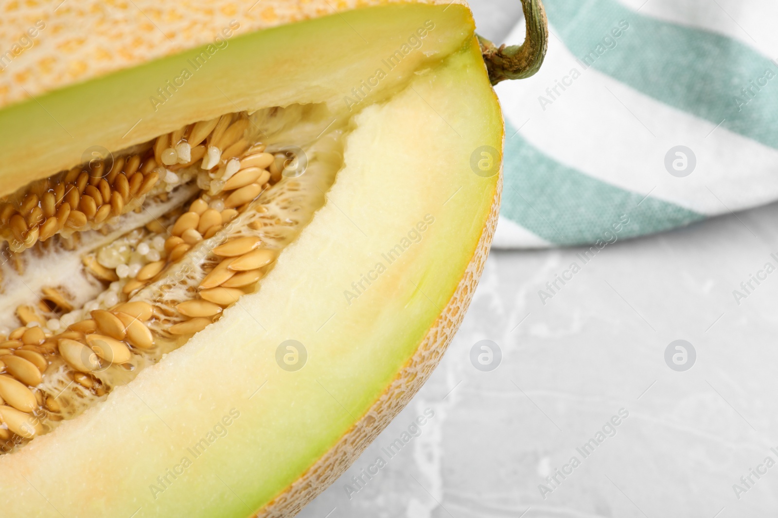 Photo of Sliced delicious ripe melon on grey marble table, closeup