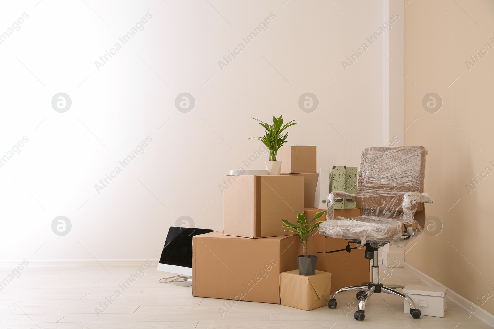 Photo of Moving boxes and furniture in new office. Space for text