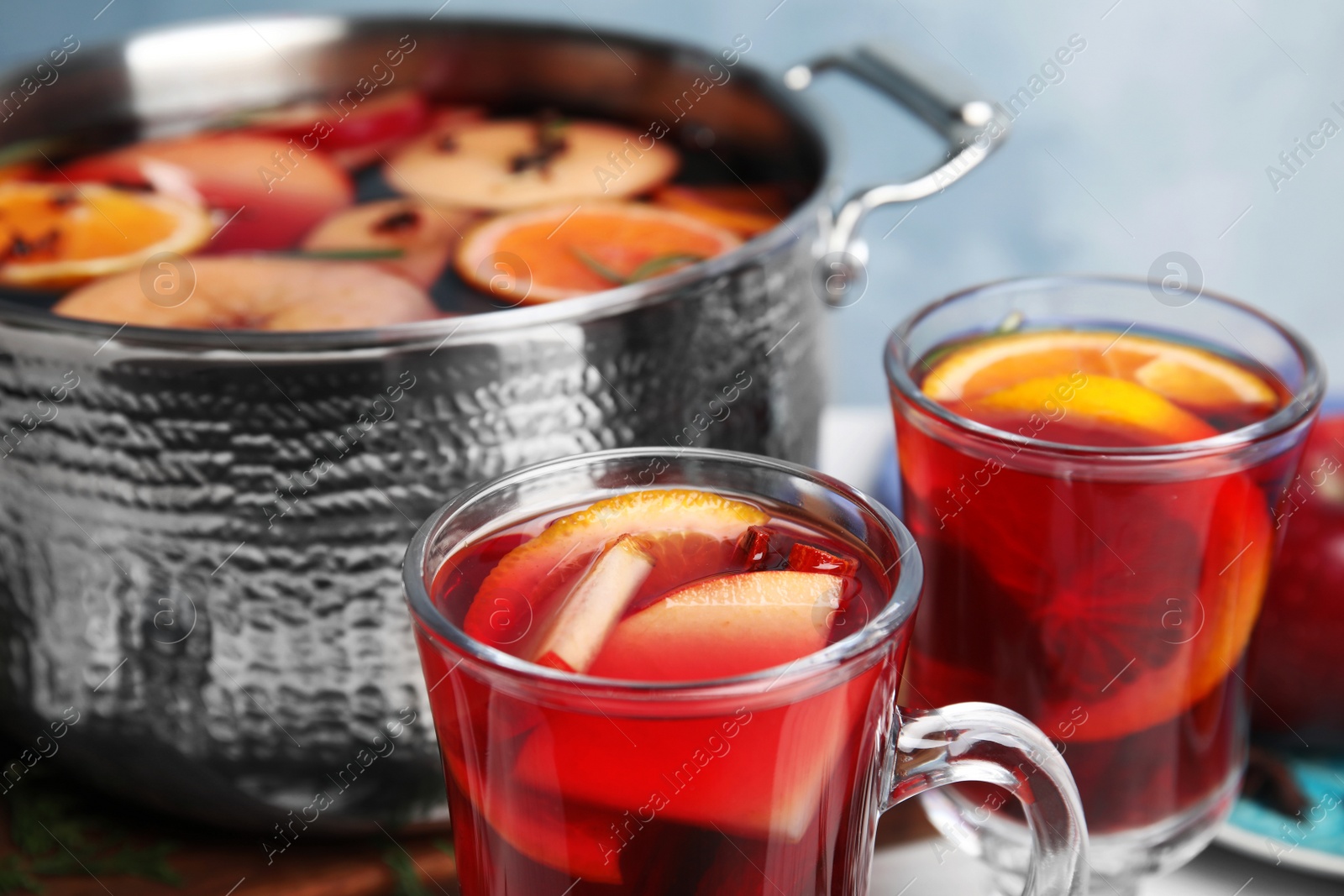 Photo of Tasty mulled wine with spices on table, closeup