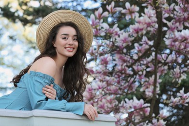 Photo of Beautiful woman near blossoming magnolia tree on spring day